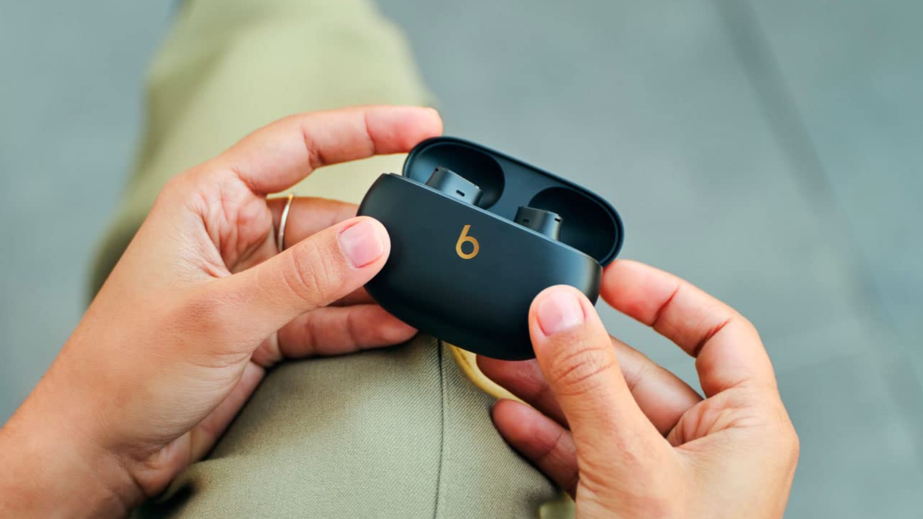 Person holding Beats Studio Buds Plus in charging case
